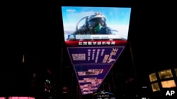 资料照片：北京一个户外屏幕上显示的一名中国战斗机飞行员在演习中竖起大拇指。(2023年4月10日)