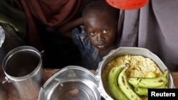 A boy waits for food during a food distribution from an international Non-government Organization (NGO) in Mogadishu June 30, 2012