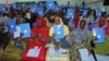 Somalia's constituency assembly members hold up copies of the proposed new constitution during the beginning of a nine-day meeting in Mogadishu, Somalia, July 25, 2012.