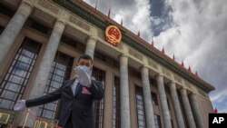 资料照：一名中国保安官员在正在举行全国人大会议的北京人大会堂外警卫。（2020年5月25日）