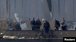 18일 자살폭탄 공격이 발생한 아프가니스탄 카불 외국인 복합단지에서 보안 요원들이 현장을 조사하고 있다.