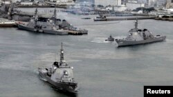 共同社的照片显示日本海上自卫队的驱逐舰开出日本南部的基地。