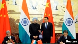Chinese Premier Li Keqiang (2nd R) and India's Prime Minister Manmohan Singh (2nd L) attend a signing ceremony at the Great Hall of the People in Beijing, Oct. 23, 2013. 