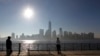 Two men look across the Hudson River at the cityscape of New York, after the One World Trade Center (C) had the final piece of its spire attached, in Jersey City, New Jersey, May 10, 2013. 