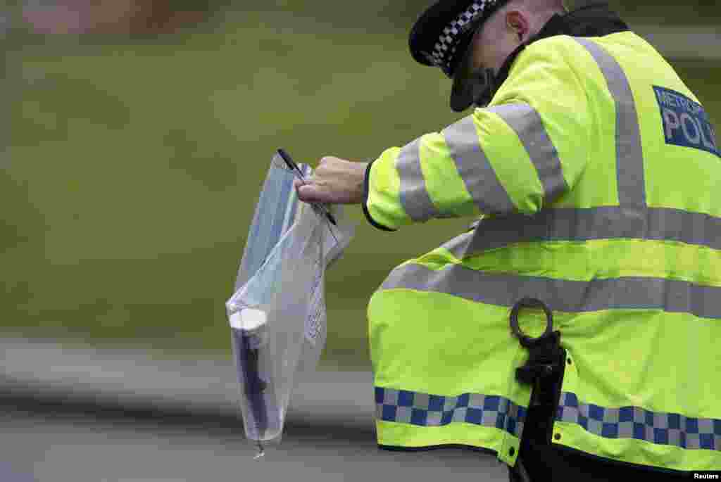 A police officer carries an evidence bag containing a knife near the scene of the killing of a British soldier in Woolwich, London, May 23, 2013. 