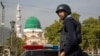 A Pakistani police officer stands guard outside the Barri Imam shrine, as security is beefed up in the capital following a suicide attack at a Sufi shrine in interior Sindh, Islamabad, Pakistan, Feb. 17, 2017.