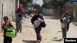 Warga Palestina melarikan diri dari rumah mereka sewaktu tank Israel menggempur kota Rafah di Jalur Gaza 1 Agustus 2014.