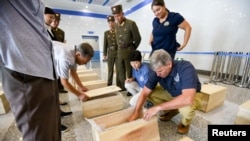 지난해 7월 북한 원산에서 미국 국방부 전쟁포로·실종자 확인국(DPAA) 관계자들이 북한군이 지켜보는 가운데 송환된 한국전 참전 미군 유해를 조사하고 있다.