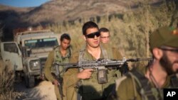 Israeli soldiers secure a road leading to where projectiles fired from Syria hit the Israeli-controlled part of the Golan Heights, near Majdal Shams, Sept. 13, 2016. From its onset in Iraq and Syria in 2014, IS has often threatened to attack Israel, and its leaders have said conquering Jerusalem would be their ultimate objective.