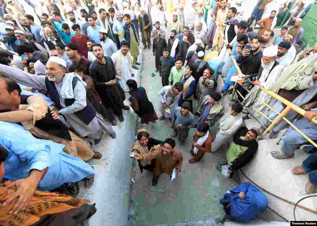 아프가니스탄 동부 자랄라바드에서 파키스탄 비자 신청에 필요한 교환권을 받으려는 남성들이 기다리고 있다. 빈곤과 박해를 피해 파키스탄에 이주하기를 원하는 수천명의 아프간 국민들이 교환권을 받기 위해 몰려 들어 사상자가 발생했다. 