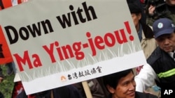 Seorang demonstran membawa spanduk yang menyerukan mundurnya Presiden Ma dalam protes di Taipei menentang kebijakan-kebijakan ekonominya hari Minggu (13/1).
