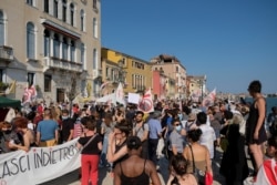 Protesters form a human chain next to the water, demonstrating against mass tourism in the city after the lockdown due to the spread of the coronavirus (COVID-19) disease, in Venice, Italy. June 13, 2020.