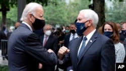 Mgombea Urais wa chama cha Demokratik ambaye alikuwa Makamu wa Rais Joe Biden akisalimiana na Makamu wa Rais Mike Pence katika maadhimisho ya 19 ya shambulizi la kigaidi la Sept. 11 Katika eneo la kumbukumbu ya taifa ya Septemba 11, New York, on Ijumaa, Septemba 11, 2020.