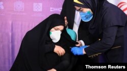 A nurse prepares to inject a volunteer taking part in an Iranian coronavirus disease (COVID-19) vaccine trial in Tehran