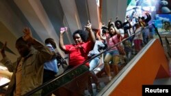 Warga sipil keluar dari pusat perbelanjaan Westgate di Nairobi dikawal petugas keamanan (21/9).