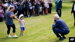 拜登总统在弗吉尼亚州约克镇的约克高中外停留期间与一对母子互动。(2021年5月3日)