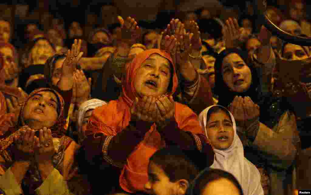 Warga Muslim Kashmir mengangkat tangan mereka melihat barang pusaka tokoh sufi Sheikh Abdul Qadir Jeelani yang ditampilkan di altar pemujaan di Srinagar, India.