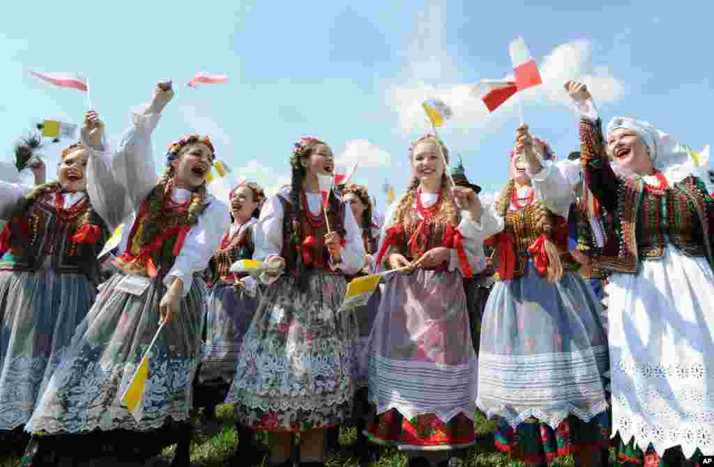 Sebuah grup tari tradisional melakukan latihan menjelang kedatangan Paus Fransiskus di bandara militer di kota Krakow, Polandia.