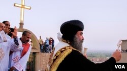 Le pasteur du monastère applaudit les coptes venus assister à la cérémonie de la Vierge Marie dans la montagne de Dronka à Assiout, en Égypte, le 20 août 2017. (H. Elrasam / VOA)