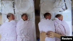 A nurse takes care of quadruplets at a hospital in Shanghai January 11, 2007. China's population will increase by 200 million in 30 years, according to a report published on Thursday, Xinhua News Agency reported. CHINA OUT REUTERS/China Daily (CHINA) - RT