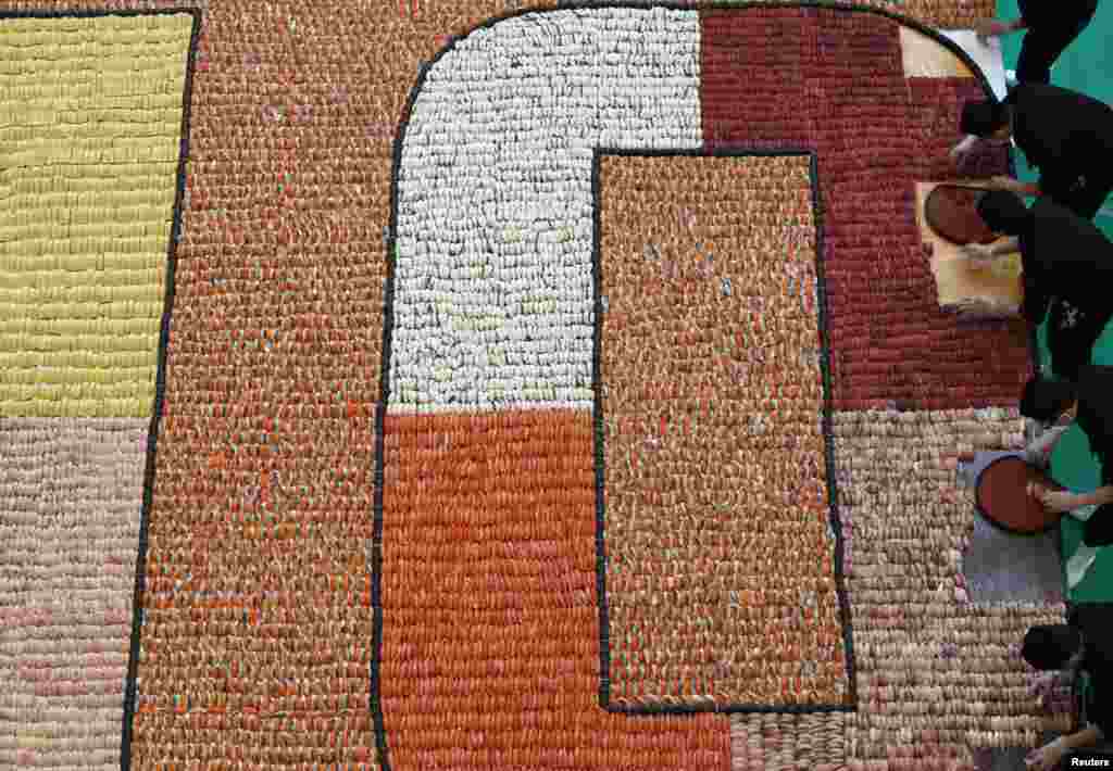 Participants arrange sushi to create the largest sushi mosaic in an attempt to break the Guinness World Records during the 10th anniversary of a sushi chain store in Hong Kong. A total of 20,647 sushi pieces were used for a 37-square-meter space to break the record, which was verified and announced by the Guinness World Records at the end of the event.