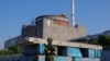 FILE - A Russian service member stands guard at a checkpoint near the Zaporizhzhia nuclear power plant outside Enerhodar in the Zaporizhzhia region, Russian-controlled Ukraine, June 15, 2023. 