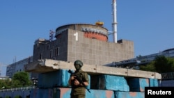 FILE - A Russian service member stands guard at a checkpoint near the Zaporizhzhia nuclear power plant outside Enerhodar in the Zaporizhzhia region, Russian-controlled Ukraine, June 15, 2023. 