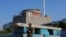 FILE - A Russian service member stands guard at a checkpoint near the Zaporizhzhia nuclear power plant outside Enerhodar in the Zaporizhzhia region, Russian-controlled Ukraine, June 15, 2023. 