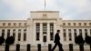 FILE - A man walks past the Federal Reserve Bank in Washington, D.C.