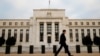 FILE - A man walks past the Federal Reserve Bank in Washington, D.C.