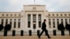 FILE - A man walks past the Federal Reserve Bank in Washington, D.C.