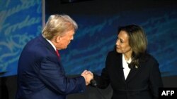 2024年9月10日，美国副总统兼民主党总统候选人卡玛拉·哈里斯(Kamala Harris)(右)在宾夕法尼亚州费城国家宪法中心举行的总统辩论中与美国前总统、共和党总统候选人唐纳德·特朗普(Donald Trump)握手。（索尔·勒布/法新社拍摄）