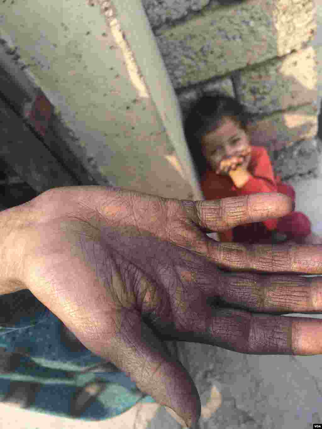 Warga mengatakan bahwa residu dari asap kebakaran melapisi pakaian dan kulit mereka, dan di rumah tangga ini, hampir tidak ada air untuk minum di Qayyarah, Irak (24/10). (VOA/H. Murdock)