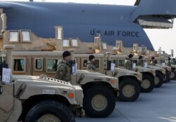 FILE - Ukrainian servicemen are seen after a welcoming ceremony for a plane from the United States with aid, including ten Humvee vehicles, at Borispil airport near Kyiv, March 25, 2015.