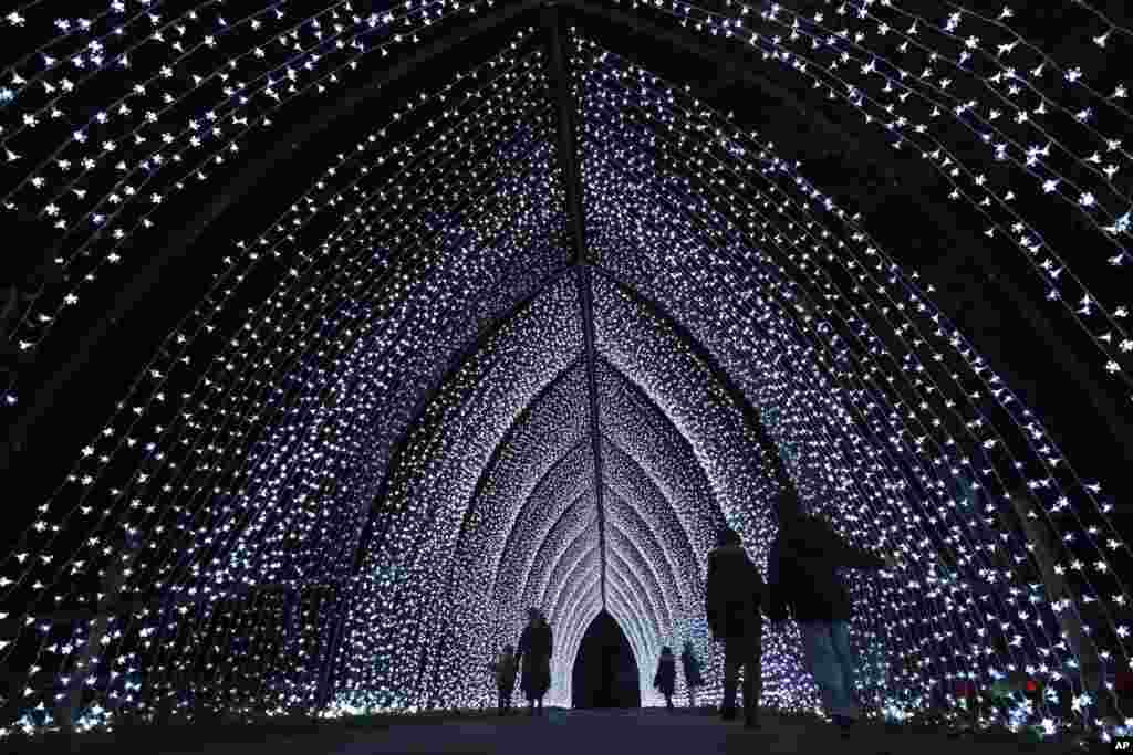 Visitors walk through the &#39;Cathedral&#39; on the Christmas light trail as it returns for its 12th year, with a showcase of new installations set in the UNESCO World Heritage Site landscape of Kew Gardens in London, Nov. 12, 2024.