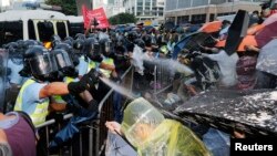 28일 수만명의 시위대가 홍콩 정부 청사 인근에 모인 가운데 홍콩 경찰이 최루탄을 발사하고 있다 