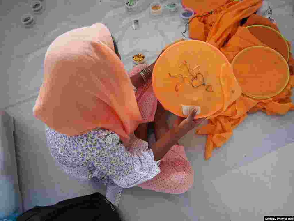 Seorang anak perempuan Rohingya sedang menyulam di tempat penampungan di Aceh.