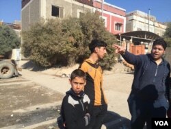 Residents point to sniper positions on top of their homes under IS rule in Mosul, Iraq, Feb. 8, 2017. (H.Murdock/VOA)