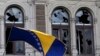 A Bosnian and Herzegovina national flag is seen on a damaged government building in Sarajevo February 8, 2014. Protesters across Bosnia set fire to government buildings and fought with riot police on Friday as long-simmering anger over lack of jobs and political inertia fuelled a third day of the worst civil unrest in Bosnia since a 1992-95 war. REUTERS/Antonio Bronic 