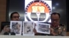 At a press conference in Jakarta, Indonesian National Police spokesperson Brig.Gen. Dedi Prasetyo, right, and an aide show photos of evidence of confiscated items during raids following a knife attack against an Indonesian official, Oct. 14, 2019. 