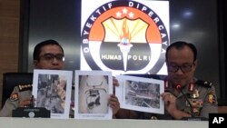 At a press conference in Jakarta, Indonesian National Police spokesperson Brig.Gen. Dedi Prasetyo, right, and an aide show photos of evidence of confiscated items during raids following a knife attack against an Indonesian official, Oct. 14, 2019. 