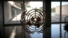 FILE - The United Nations logo is seen on a window in an empty hallway at United Nations headquarters in New York.