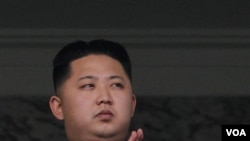 Putera pemimpin Korea Utara Kim Jong-il, Kim Jong-un, bertepuk tangan saat menyaksikan parade militer akbar di Pyongyang hari ini.