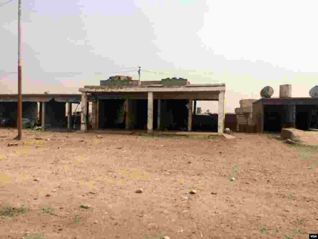 Rumah-rumah dan tempat-tempat usaha di wilayah Qayyarah, Irak, yang tadinya dikuasai oleh kelompok militan Negara Islam (ISIS) ini telah dibom oleh serangan udara koalisi (24/10). (VOA/H. Murdock)