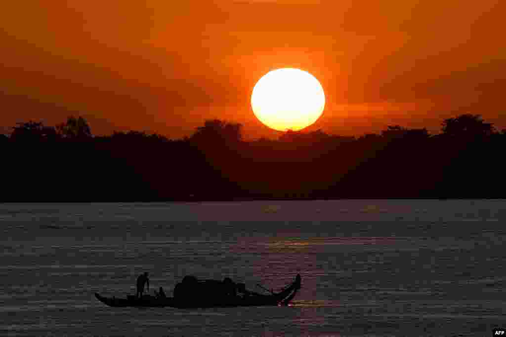 캄보디아 프놈팬 메콩강에서 일출을 배경으로 어선이 떠있다. 