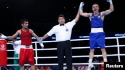 Pakistan's Muhammad Waseem (L) and Australia's Andrew Moloney react to the result of their boxing match at the 2014 Commonwealth Games in Glasgow, Scotland August 2, 2014. (REUTERS/Russell Cheyne)