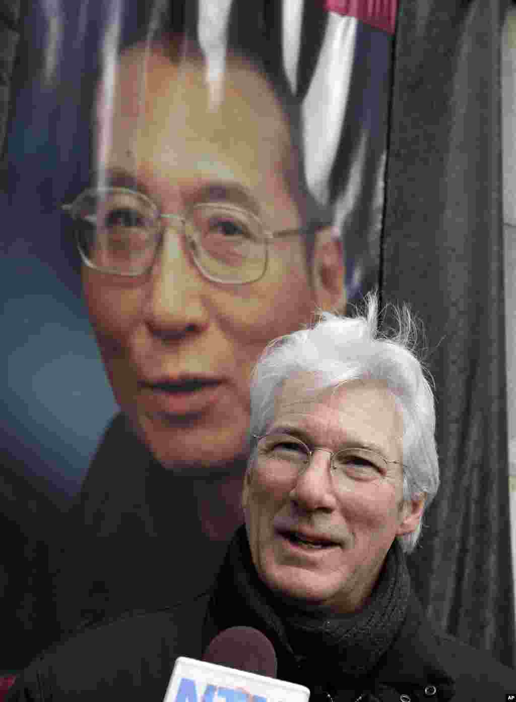 在纽约联合国总部对面的集会中，在刘晓波的照片前面，美国著名演员理查德·吉尔接受采访（2012年12月10日）