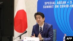 In this handout photograph received by Jiji Press and released by Japan's Cabinet Public Relations Office, Japan's Prime Minister Shinzo Abe speaks from Tokyo with other Asean leaders during a video conference on April 14, 2020. - Leaders of Japan,…