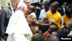 Le pape François embrasse un enfant dans un camp de déplacés, Bangui, 29 novembre 2015.