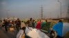 Volunteers put up tents for protesting farmers in the middle of a major highway which is blocked in a protest against new farm laws at the Delhi-Uttar Pradesh state border, India, Dec. 25, 2020.